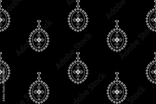 Elegant seamless ethnic pixel pattern with intricate droplet-like motifs in white on a striking black background. Perfect for modern fashion and textile design.
