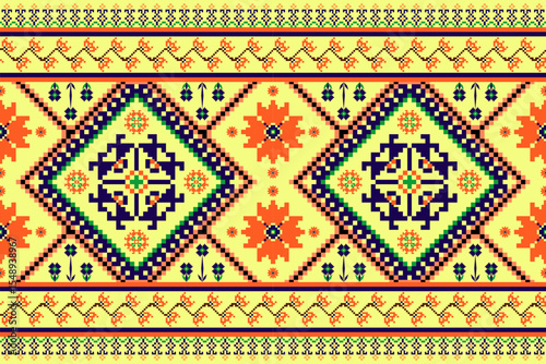 Vibrant seamless ethnic pixel art pattern with intricate geometric and floral motifs in orange, blue, and green on a cheerful yellow background. Ideal for textiles, folk-inspired fashion, and digital 
