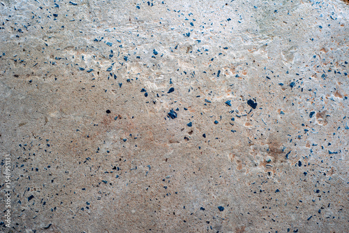 The concrete cement floor is dirty, has been washed and washed until the gravel is visible.