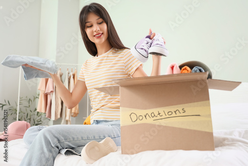 Young woman packing clothes...