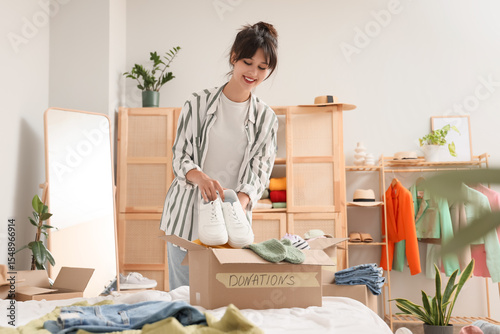 Young woman packing shoes i...