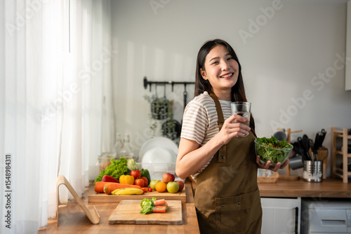 Portrait of Asian woman eating healthy salad and drink clean water. 