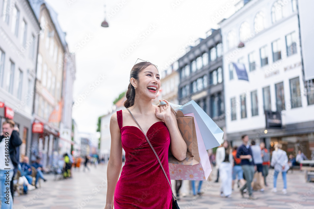 Fototapeta premium Asian woman holding shopping bags and walking at outdoors marketplace. 