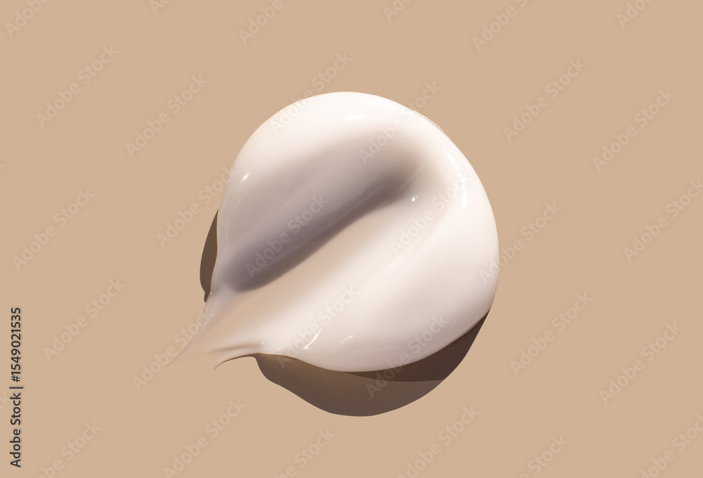 Fototapeta premium sample smear of creamy white texture on light beige background close up