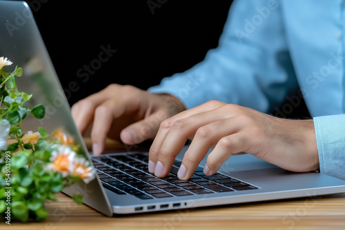 Working on a laptop with a plant in the background at home