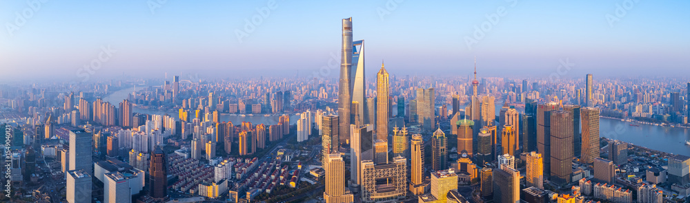Obraz premium Aerial view of Shanghai skyline with winding river at sunrise.