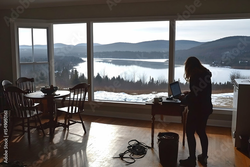Woman working on laptop with scenic lake and mountain view from
