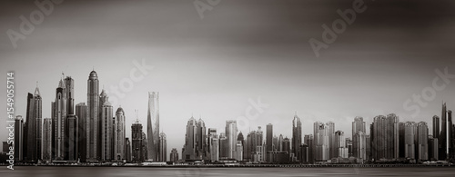 Photography Monochrome city skyline with tall skyscrapers reflecting on calm water under a c