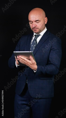 Businessman using digital tablet on black background