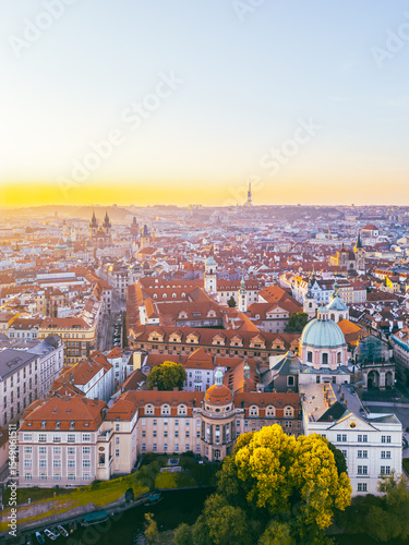 A breathtaking aerial perspective of Old Town Prague during sunrise showcases the vibrant rooftops and historic architecture.