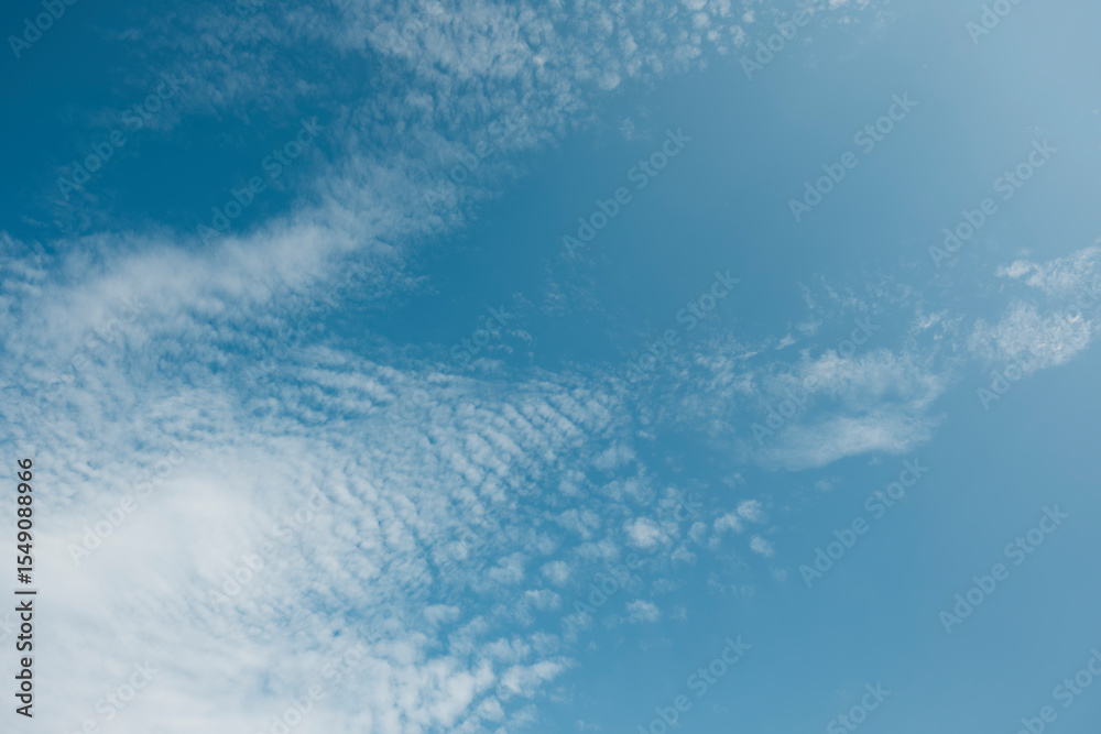 Obraz premium ふわふわした薄い雲と夏のようなさわやかな青空 風に流れる雲と美しい天気 