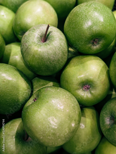 Vertical photo of fresh green apples stacked at a farmer's market