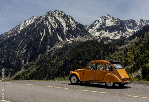 Vintage Citroën 2CV with snow-covered mountain in the Pyrenees