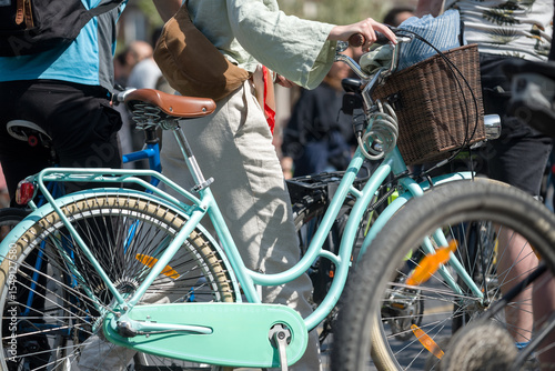 Detail of person rolling a bicycle in a crowd