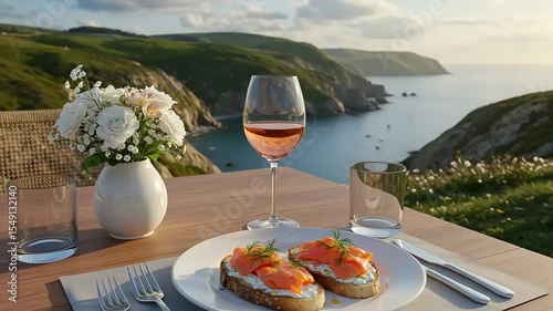 Scenic outdoor dining with salmon toast, wine, and flowers overlooking a coastal view
