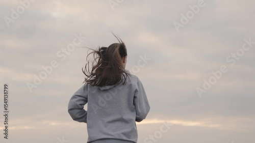 girl in sportswear runs against the sky at sunset, womens long-distance jogging, healthy lifestyle, cardio training for a slim figure and a healthy heart, striving to be first, run in morning at dawn.