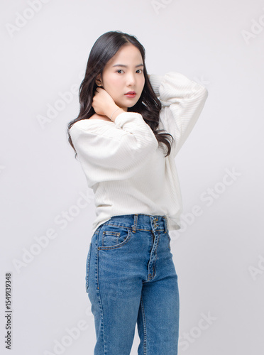 Half body portrait happy smile young asian beautiful woman curly hair wearing long sleeve shirt, blue jeans outfit, casual standing pose on white background joy positivity fashion lifestyle concept.
