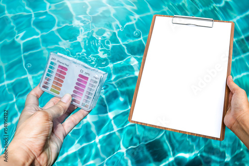 Water testing test kit in dipping in clear swimming pool water with blank report paper on wooden clipboard, quality water tester