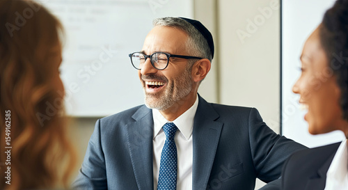 Smiling middle-aged man in formal suit, engaging in conversation with two women in a professional setting, showcasing teamwork and collaboration in a business environment