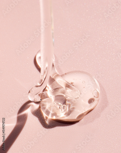 cosmetic sample of transparent gel texture on pink background