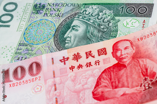 100 Polish zloty and 100 New Taiwan dollar banknotes. International trade concept