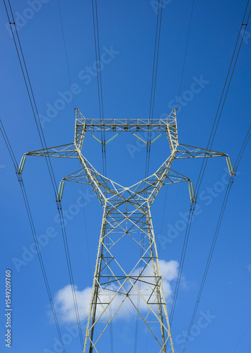 Power line pylon against a blue sky with clouds