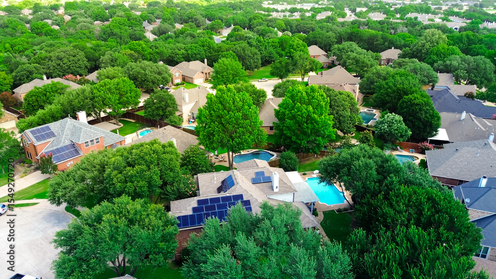 Fototapeta premium Aerial view lush green homes with rooftop solar panel arrays, angled installations for optimal sunlight capture, supporting clean efficiency energy, lower bills, sustainable, DFW metroplex, Texas
