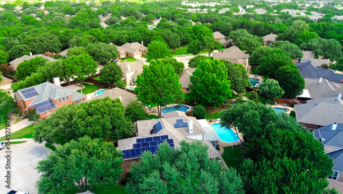 Aerial view lush green homes with rooftop solar panel arrays, angled installations for optimal sunlight capture, supporting clean efficiency energy, lower bills, sustainable, DFW metroplex, Texas