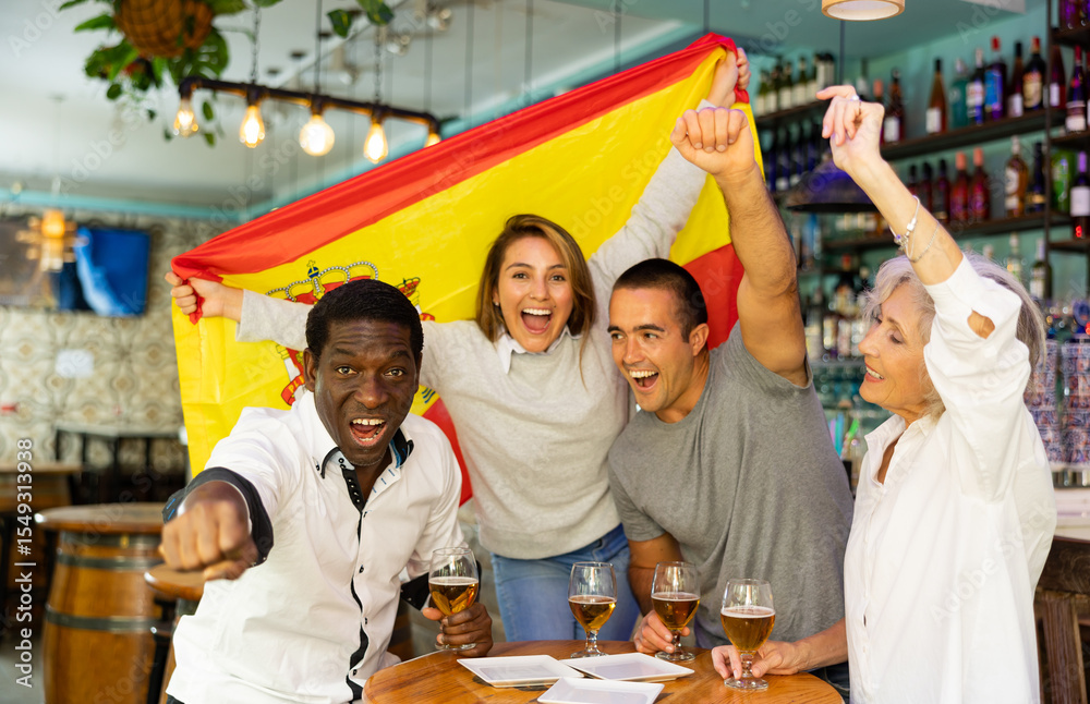 Obraz premium Happy diverse group celebrating Spain at a bar with beer