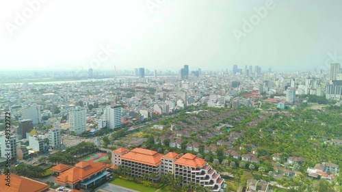 Aerial view of ho chi minh city skyline showing buildings, skyscrapers, river, green areas, and orange roofs in district 7, vietnam, on a sunny day