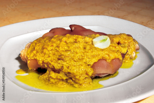 Pig's trotters with mustard sauce and garlic on white plate