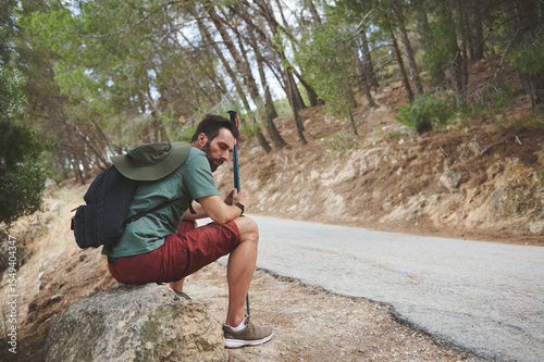 Hiker Taking a Rest Along a Forest Trail with Scenic Surroundings