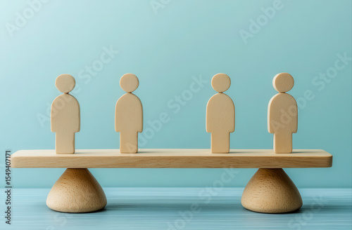 Wooden figures balanced on a seesaw (1)
