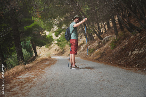 Hiker Strolling Along Forest Path in Serene Mountain Landscape
