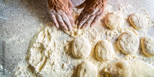Homemade cakes dough in the women's hands. Process of making pies, hand. Hands pie dough. Cooks dough for baking, pieces of raw dough. Womans hands rolling doughs for pies. Baking at home