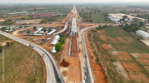 Drone shot of highway and overpass construction site with vehicles and road