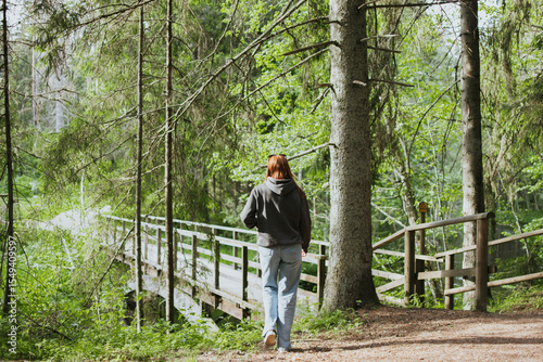 Red hair woman walking in nature in the forest for health. Travel to another country for hiking