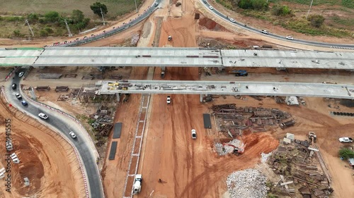 Drone shot of highway and overpass construction site with vehicles and road for infrastructure civil industry engineering and transportation concept