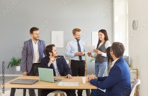 Young confident business people talking about company growth and finance discussing job project on meeting. Employees sitting in modern office with colleagues on work conference. Teamwork concept