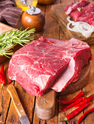 Raw meat on cutting board, with herbs, spices on cooking table top view copy space