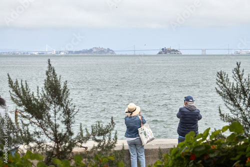 Tourists Photographing San Francisco Bay with Alcatraz Island in Distance
