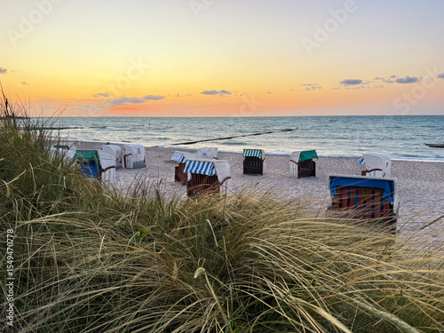 beautiful view to colorful wooden beach chairs on the coast in sunset light	
