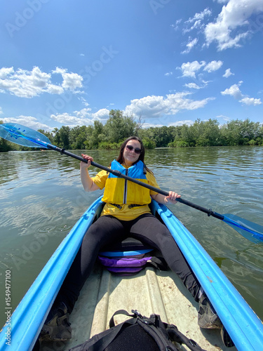 Woman Kayaking on a Calm River. Peaceful Outdoor Adventure.