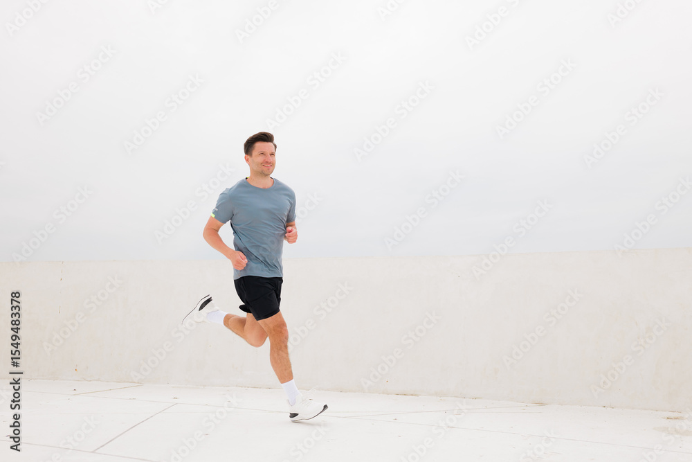 Morning jog at the seaside promenade captures a runner's determination against a backdrop of tranquil, overcast skies Morning jog at the seaside promenade captures a runner's determination against a backdrop of tranquil, overcast skies