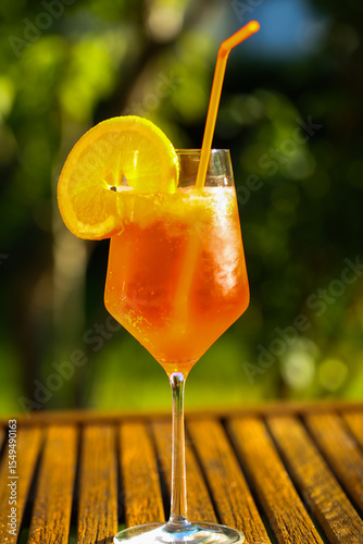 Aperol Sprizz mit Orangenstück  auf Gartentisch