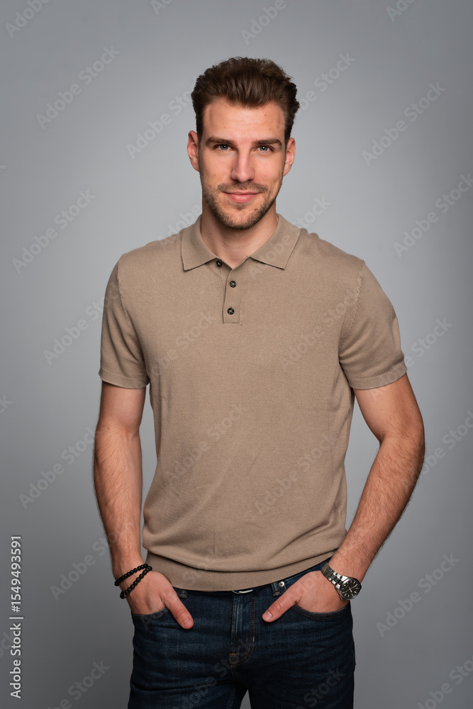 Fototapeta premium Portrait of a handsome young man standing against isolated grey background