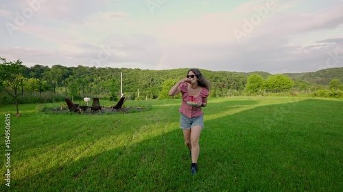 young curly woman holding bowl of freshly picked apricots from the garden. Summer garden. Slow life and eco conscious concept 