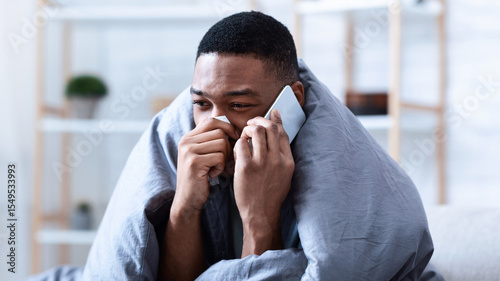 Schilderij op canvas Ill Black Man Calling Doctor Having Runny Nose Suffering From Cold And Rhinitis Sitting On Sofa At Home