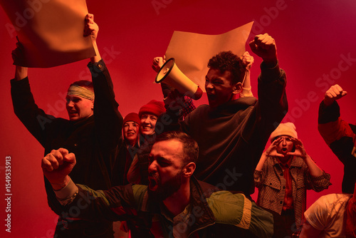 Fotografia A group of diverse individuals passionately protest with signs and a megaphone under dramatic red lighting