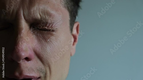 Tear rolling down a man's cheek. Close up of Crying man with tears in eye
